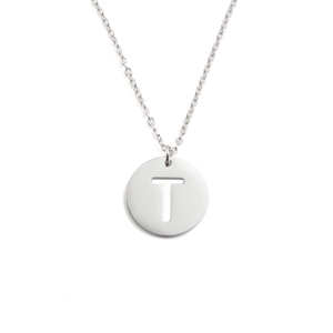 Détail macro du collier en acier inoxydable argenté avec pendentif rond à lettre T