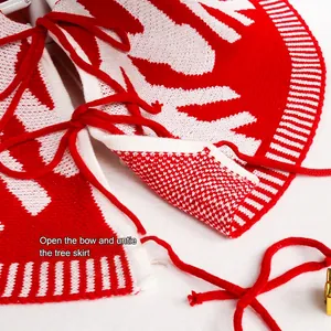 Graue gestrickte Weihnachtsbaumdecke mit weißen Schneeflocken und roten Bändern