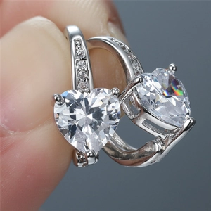Macro shot of silver earrings featuring large heart-cut cubic zirconia in claw settings