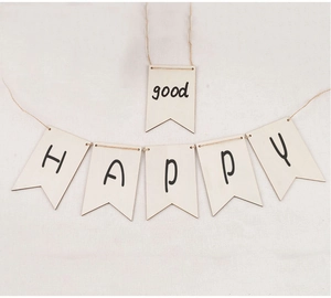 Close-up of DIY wooden HAPPY banner flags with rustic twine on linen texture