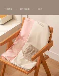Detail of pink and beige waterproof apron with plush pocket on a wooden chair