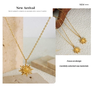 Detailed close-up of a 18K gold sun pendant necklace on a textured stone background