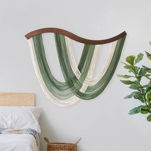 Décoration murale bohème en bois courbé avec glands en coton vert sauge et crème