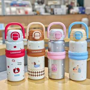 Detail of four cartoon vacuum insulated cups with portable handles on a wooden table