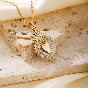 Macro shot of gold heart pendant with zircon stones on silk fabric background