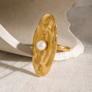 Elegant 18K gold stainless steel ring featuring oval textured metal and a white pearl