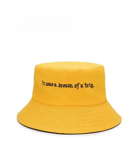 Detail of yellow canvas bucket hat with Gothic text embroidery and reinforced brim stitching