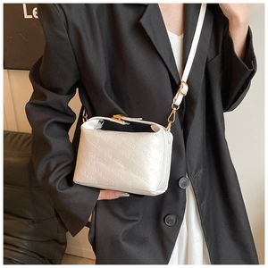 Close-up of white crossbody bag with rich rabbit embossed texture and gold hardware