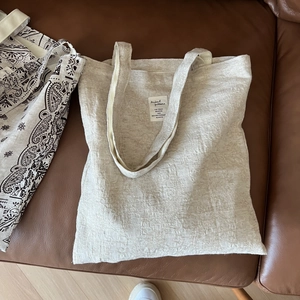 Detail of beige jacquard tote bag with cotton linen texture and long handles