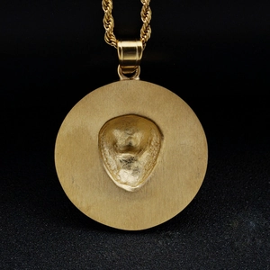 Golden hip hop necklace featuring a round pendant with a cowboy hat embossed design