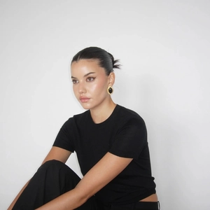 Close-up of a model wearing gold 18k stainless steel earrings with black onyx marquise stones
