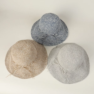 Detailed view of three hand-crocheted wide-brim straw hats in blue, tan, and gray colors.