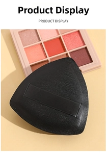 Macro shot of black triangular flocking puff with wide finger strap for loose powder