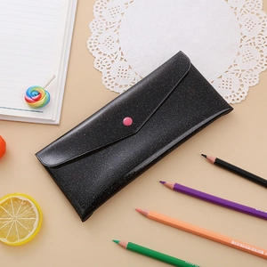 Detail of black laser pencil case with pink button closure and glitter texture finish