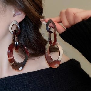 Detail of tortoise shell resin chain earrings showing glossy brown link texture