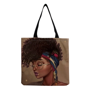 Detail of canvas tote bag with artistic African woman print and black woven handles