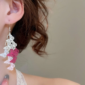 Close-up of blue and white hollow butterfly tassel earrings with gradient fringe detail