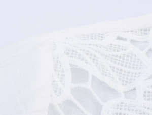 Detail showing high-quality white lace patchwork and fine stitching on the fabric