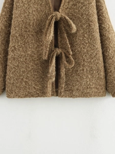 Detail of caramel brown plush cardigan jacket showing fabric texture and double tie closures