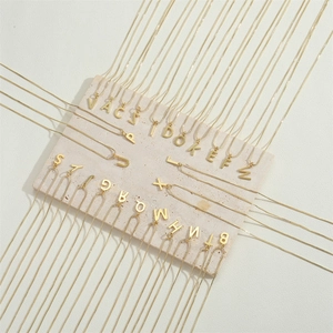 Minimalist 14K gold plated A-Z initial pendant necklace set on stone display