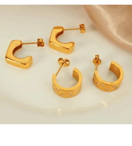 Detail of 18k gold plated geometric U-shaped and wide diamond-set hoop earrings