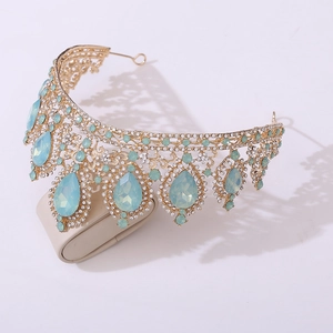 Close-up of golden bridal crown featuring light blue teardrop gems and clear rhinestones