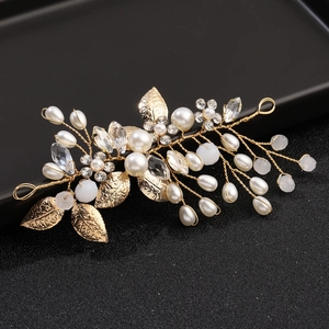 Macro shot of wedding hair vine with gold leaves, white pearls and sparkling crystals