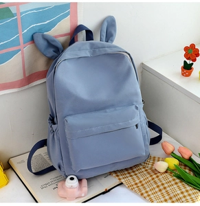 Close-up of blue backpack with cute bunny ears and aesthetic lifestyle accessories