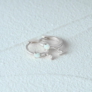 Close-up of S925 sterling silver hoop earrings with white opal and zircon charms