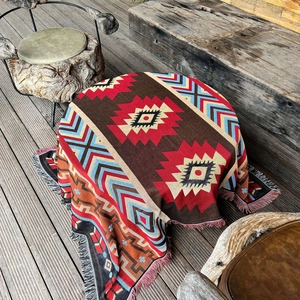 Close-up of Bohemian outdoor picnic blanket showing intricate geometric jacquard and colorful tassels