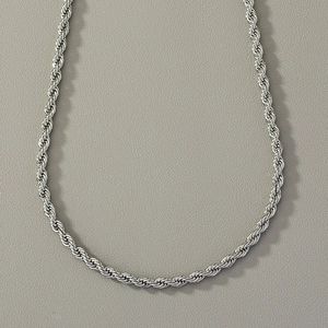 Detailed macro view of a silver stainless steel rope chain necklace with metallic luster