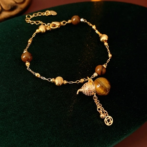 Detail von Tigerauge-Perlen und goldenem Flaschenkürbis-Anhänger an einem Vintage-Armband