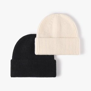 Classic black and beige knit beanies with ribbed texture and folded cuffs for winter warmth