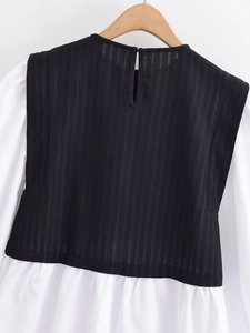Détail de la texture au dos avec tissu plissé noir et coutures d'épaule blanches