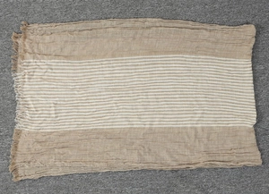 Close-up of beige and white striped scarf with detailed fringe edges and linen texture