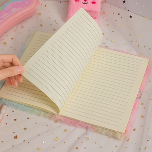 Close-up of rainbow plush cover edge and lined writing paper on cute unicorn journal