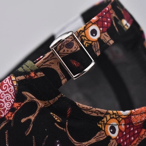 Detail of adjustable metal buckle and colorful owl print on black cotton baseball cap
