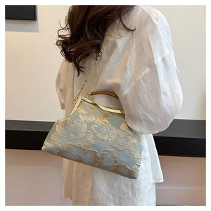 Detailed shot of vintage light blue satin bag with gold embroidery and wooden handle