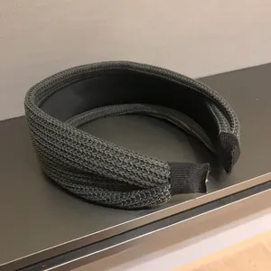 Detailed view of the dark grey knitted texture and black inner lining of the headband