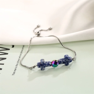 Detail of adjustable stainless steel cross bracelet with blue marble stones and silver chain