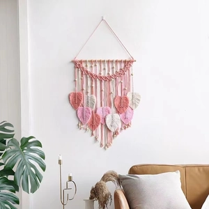 Bohemian handmade macrame wall hanging with pink and white leaf patterns and wooden beads
