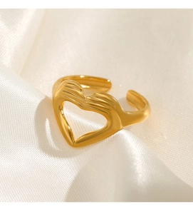 Détail d'une bague dorée en forme de cœur sur un fond de tissu en soie premium