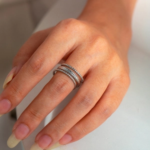 Macro shot of 925 sterling silver stacked rings featuring woven and beaded textures