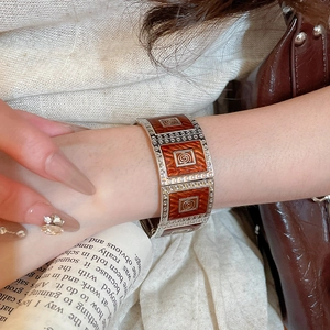 Detail of vintage silver alloy wide bracelet with reddish-brown enamel and geometric patterns