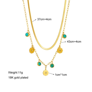 Detail of double-layer 18K gold plated necklace with turquoise beads and flower pendant