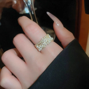 Macro shot of gold-plated ring featuring tiered white pearls and pavé cubic zirconia accents