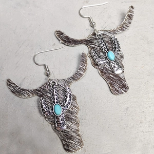 Close-up of Western style bull head earrings with leopard print leather and turquoise