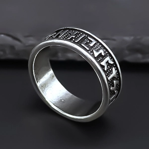 Macro d'une bague rétro argentée avec gravures de runes nordiques sur un anneau mat
