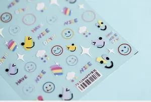 Macro shot of 3D rainbow and smiley face nail art stickers with TS-514 model detail