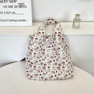 Dettaglio della borsa tote in tela bianca con orsetti carini e motivi floreali colorati